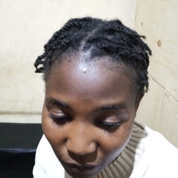 Person with braided hair photographed looking downward