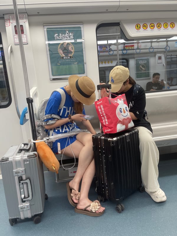 Quiet subway ride, phones out, straw hat in frame