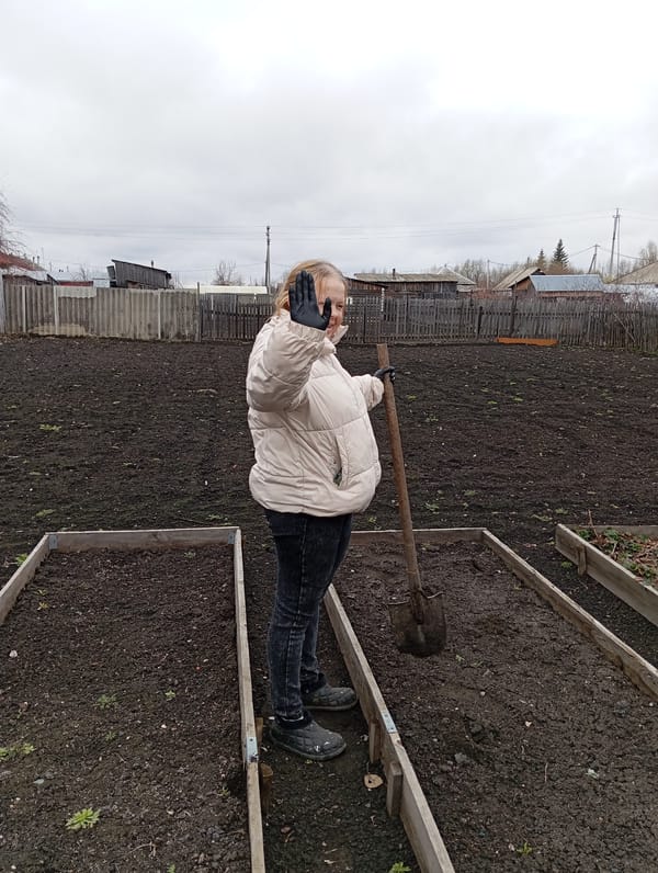 Woman tends garden in early morning Yurgamysh Russia