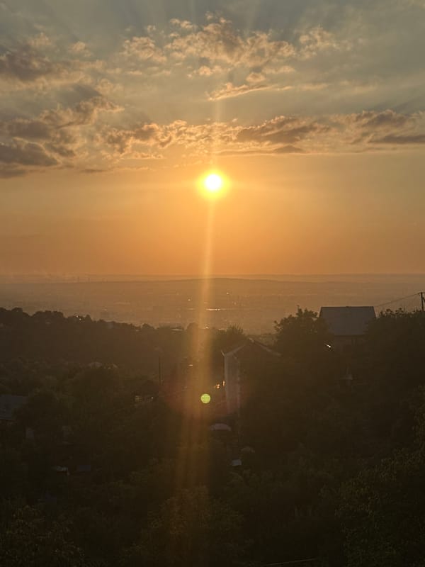 Golden sunset over Almaty, framed from a high-rise balcony