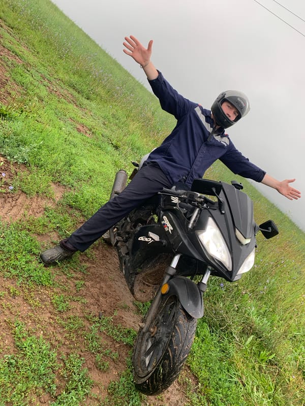 Off-road rider poses with motorcycle in muddy Panteleevka field