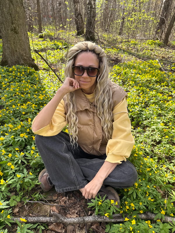 Woman poses with children among spring flowers in Rusanovo