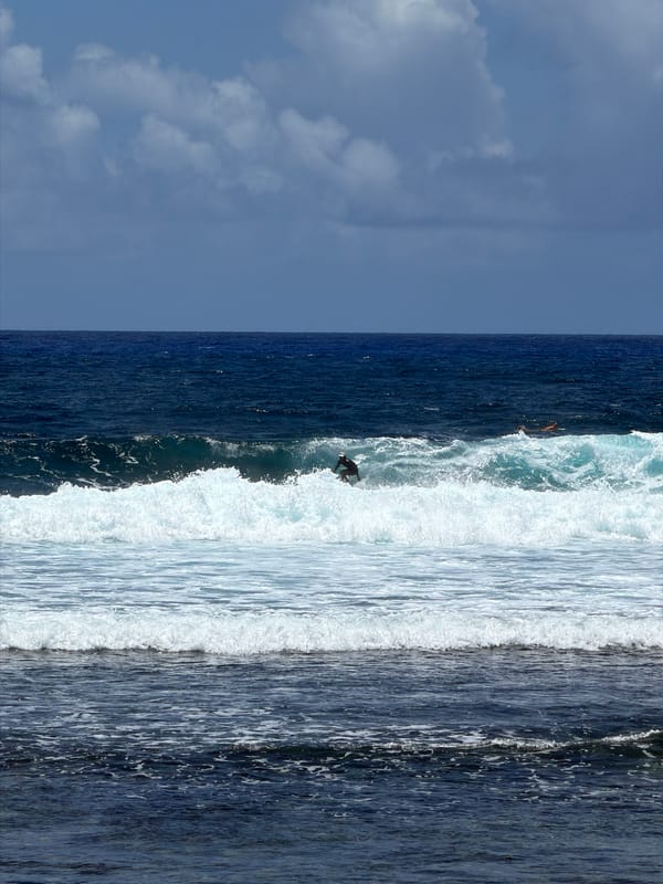 Surfer rides wave under clear skies in General Luna
