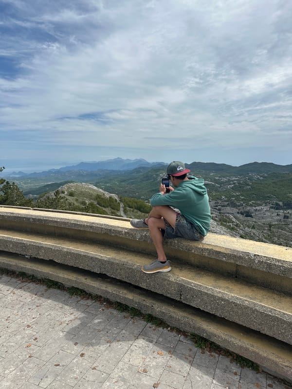 Tourist photographs mountain views at Montenegro's Lovćen National Park