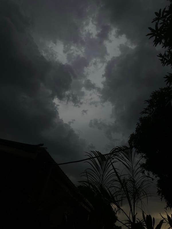Storm clouds gather over Nigerian residential area, child plays