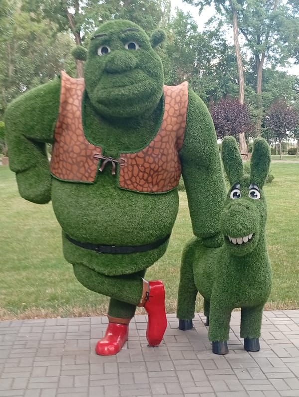 Pokrov city park with cartoon topiaries, fountains, and rides