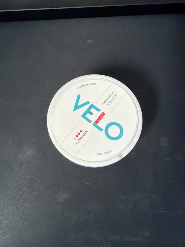 VELO nicotine pouch container photographed on dark surface