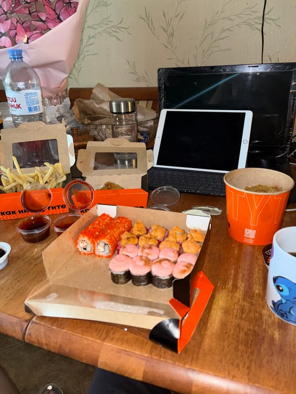 Sushi and fries takeout spread on a table in Shushary