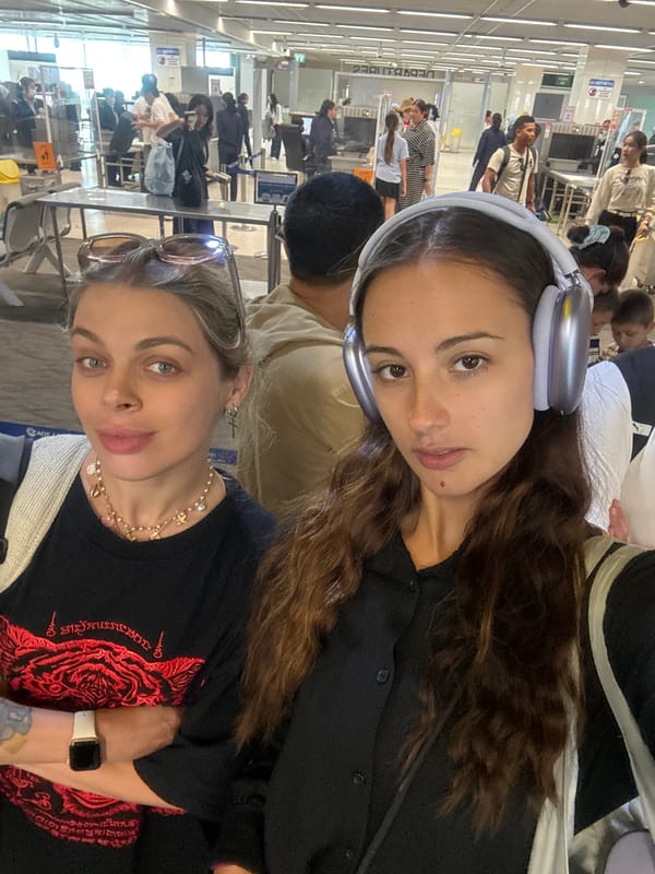 Two women document airport travel experience in Thailand