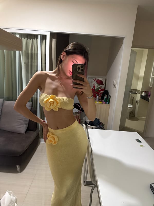 Woman takes selfie in yellow outfit at Thailand apartment