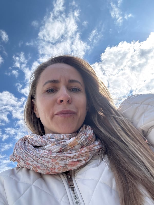 Woman takes upward-angle selfies against blue sky in Chaikovsky
