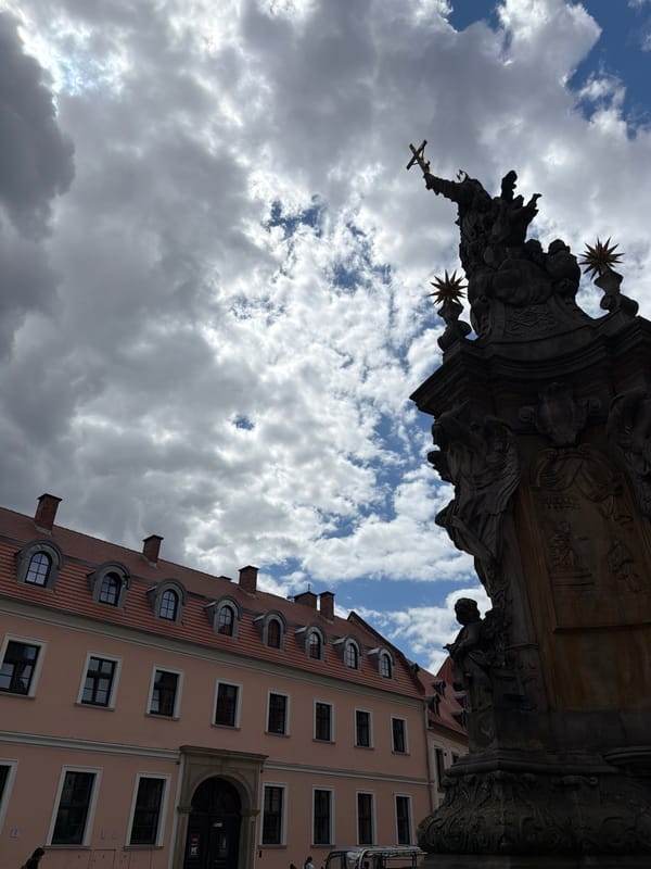 Gothic spires, stone statues, and cobblestone courtyards in a historic city center