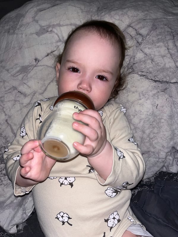 Baby feeds from bottle on patterned blanket in Shushary