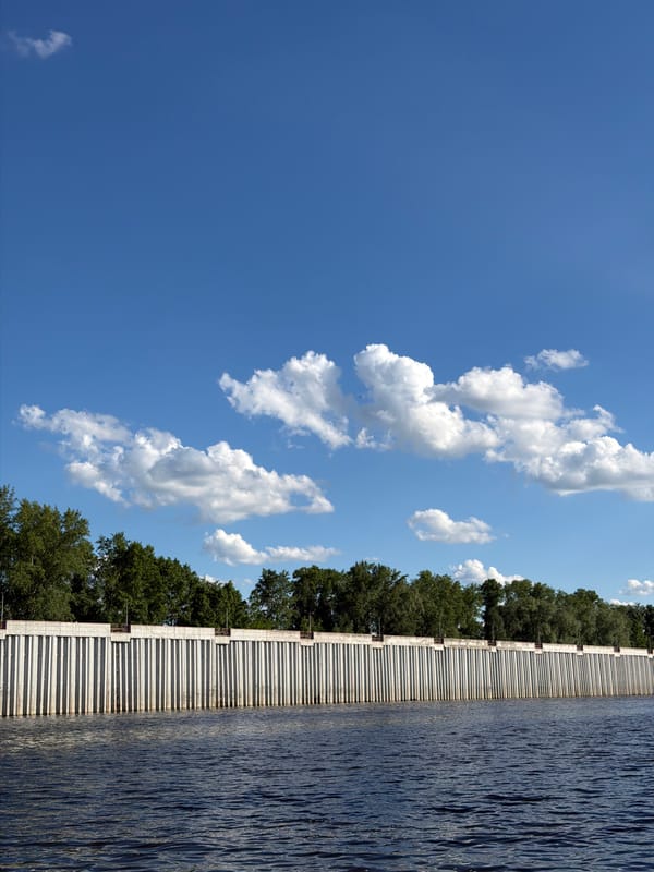 Men fishing at concrete waterway wall in Chaikovsky, Russia