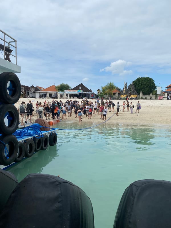 Tourists arrive by boat on a Nusa Penida beach