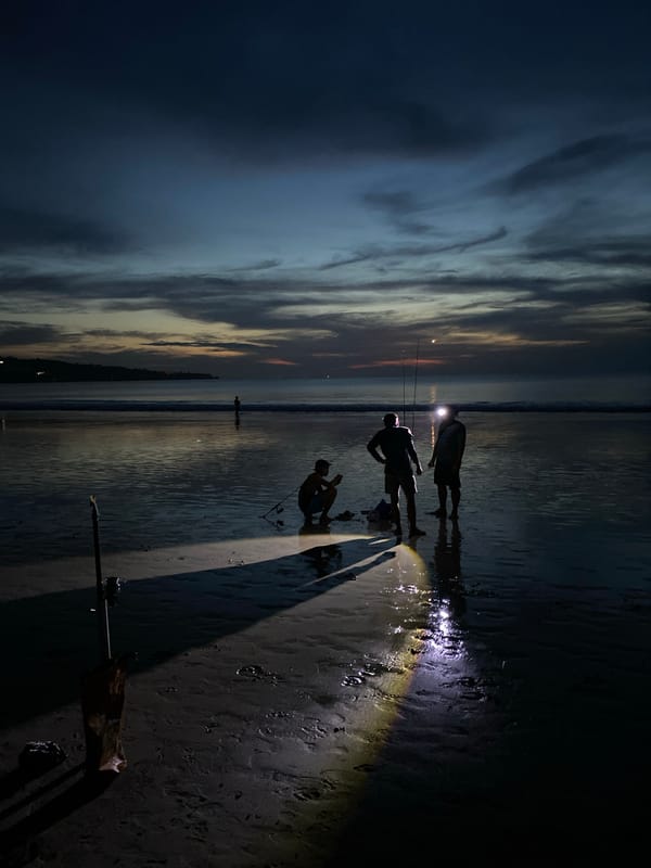 Evening beachgoers gather with flashlight in Kuta Selatan