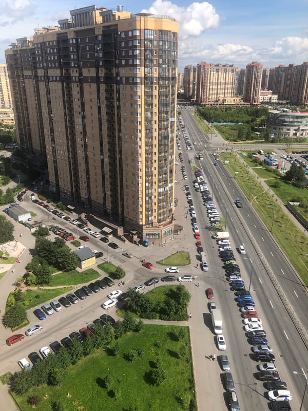 Aerial sweep of a dense residential district with a LADA dealership