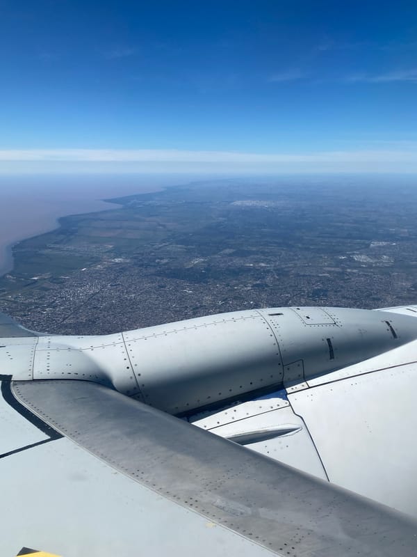 Aircraft passenger views Monte Chingolo cityscape from airplane window