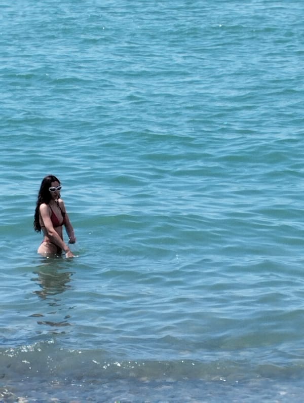 Summer day on Batumi's Black Sea beach, city rising behind it