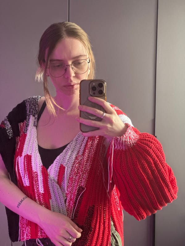 Woman documents trying on crocheted sweater in Krasnoyarsk morning