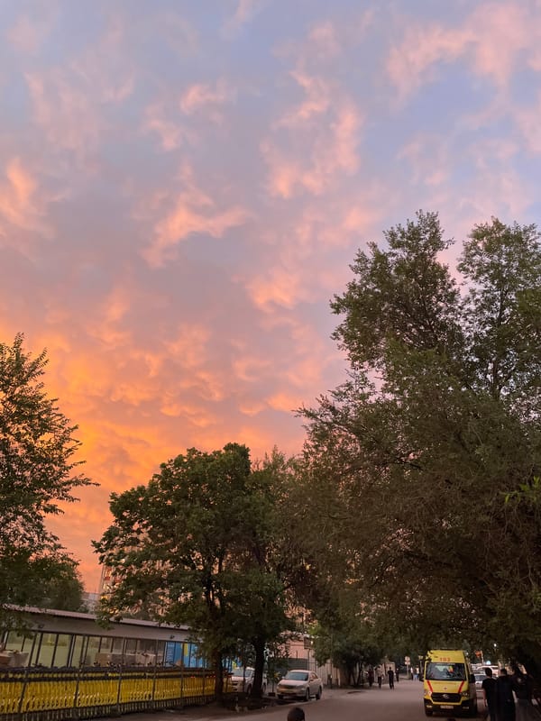 Almaty streets glow under a dramatic summer sunset sky