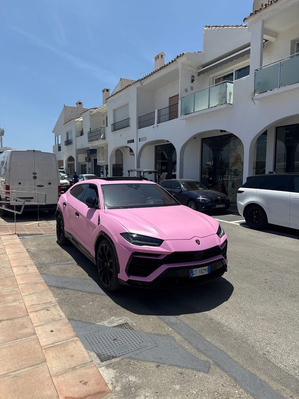 Pink Lamborghini Urus parked in sunny Marbella