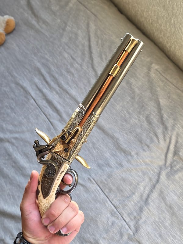 Person displays ornate antique pistol in Puebla, Mexico