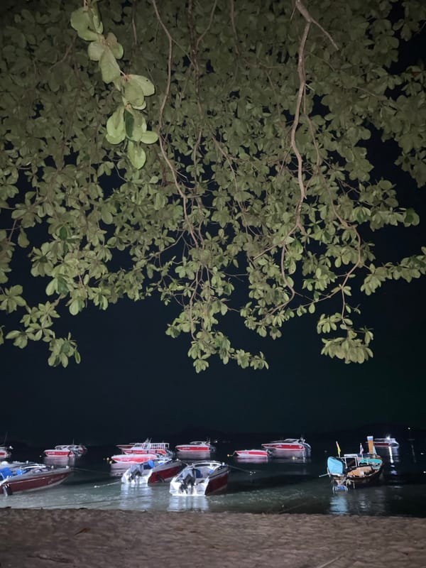 Nighttime pier scene with docked boats captured in Rawai