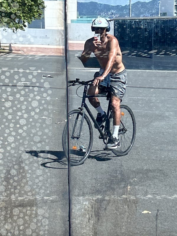 Cyclist rides through Barcelona while using smartphone and wearing headphones