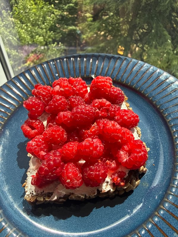 Raspberries and flowers on a ceramic plate, Sochi morning