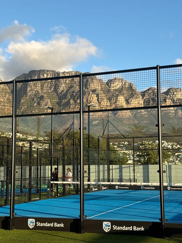 Padel players active on Cape Town court beneath Table Mountain