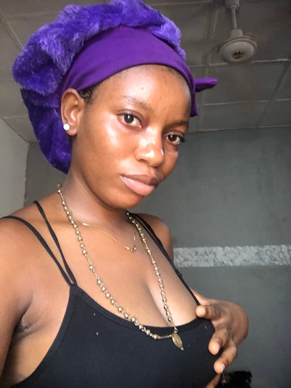 Woman in purple headwrap photographed indoors in Nigeria