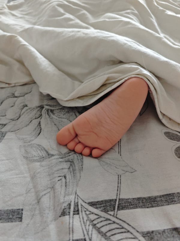 Baby's foot photographed on bedding in Markovskii, Russia