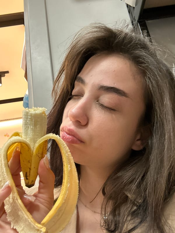 Woman holds peeled banana with eyes closed in Sofia