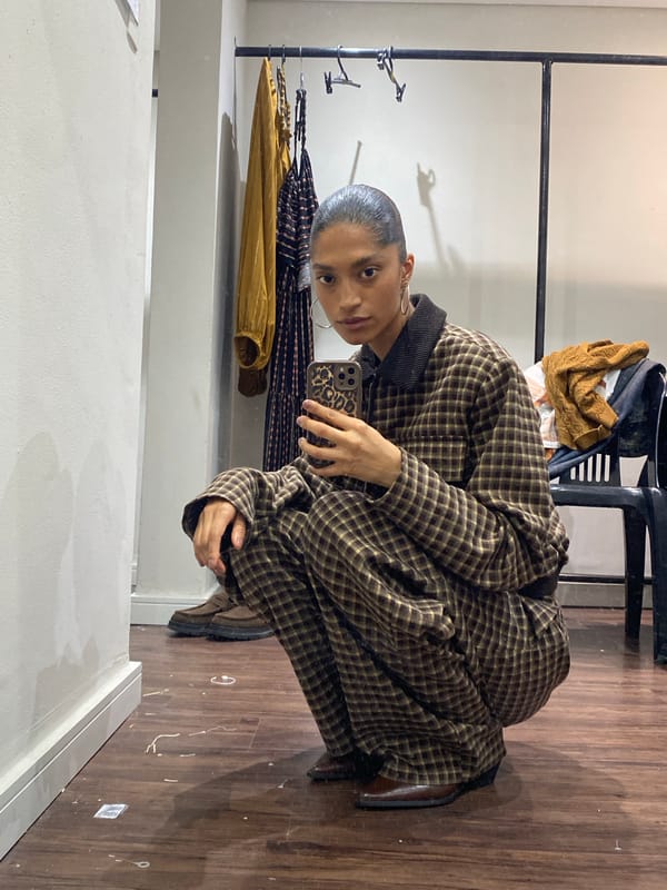 Person tries on plaid pantsuit in São Paulo fitting room