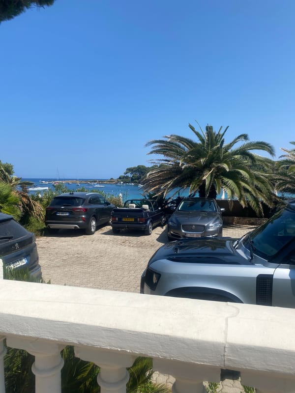 Coastal villas, rocky shoreline, and anchored yachts in Antibes