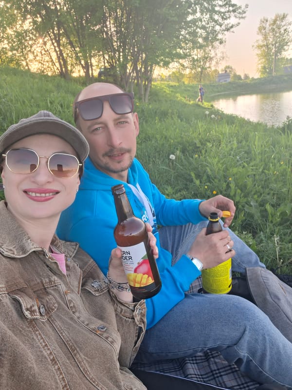 Couple enjoys afternoon picnic by Belarus waterway with drinks