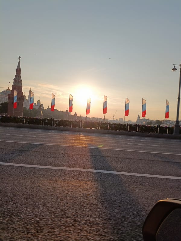 Morning sunrise illuminates Moscow's Kremlin behind Russian flags