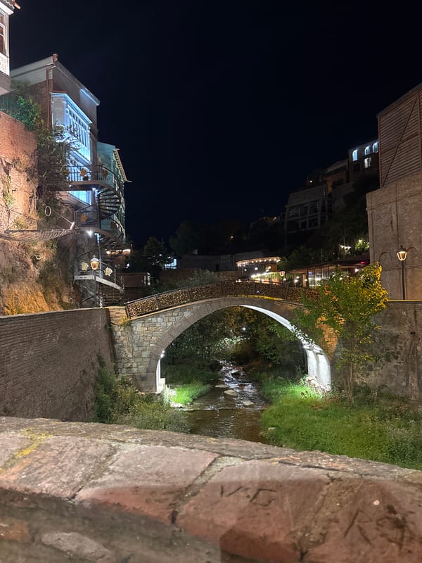 Night walk through a padlock-covered gorge with waterfall and cliffs
