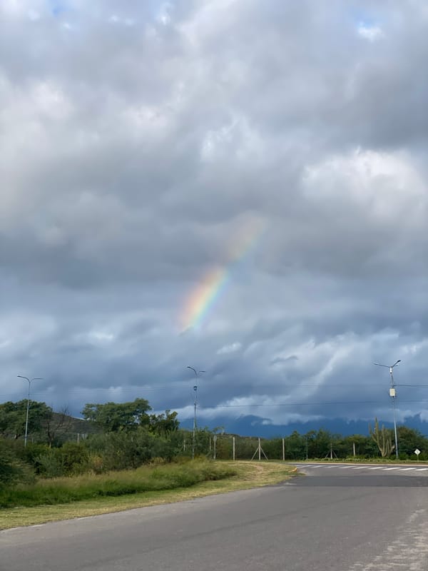Rainbow appears over Catamarca roadway during evening hours