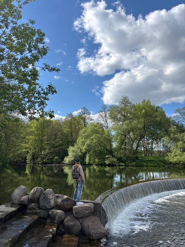 Person visits small dam waterfall in rural Belarus