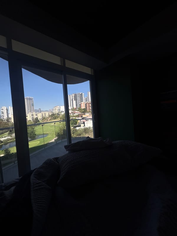 Window view captured of Huixquilucan cityscape from darkened room