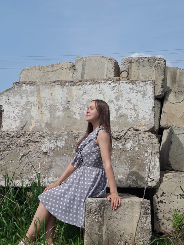 Woman rests on crumbling concrete blocks in Chaikovsky, Russia