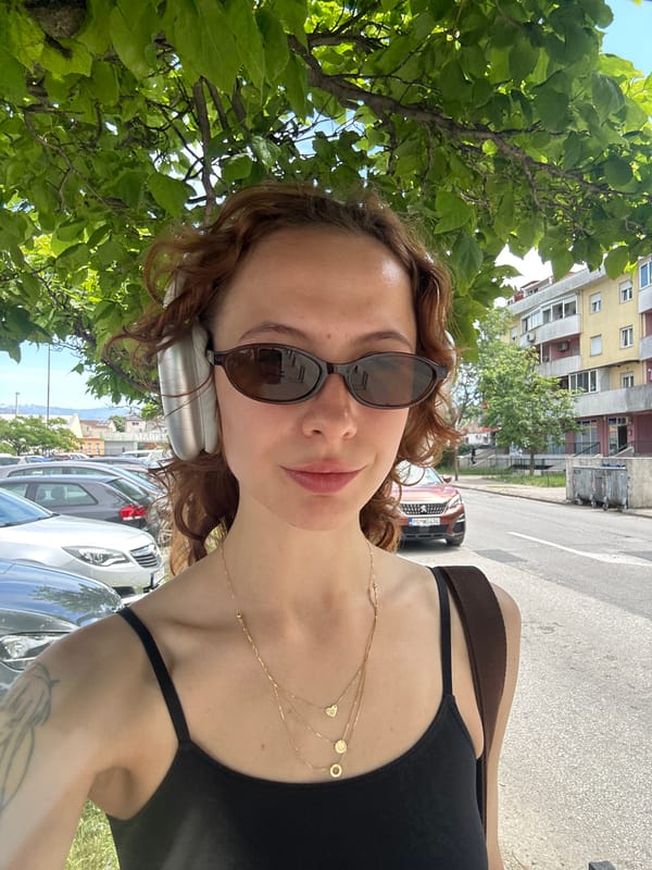 Woman takes selfie in Podgorica wearing sunglasses and headphones