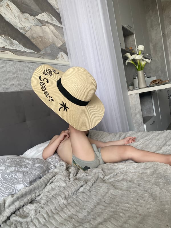 Toddler enjoys summer hat and apple during morning playtime