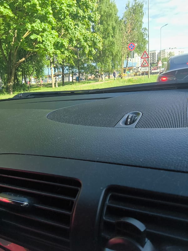 Woman makes heart gesture in car during morning in Riga