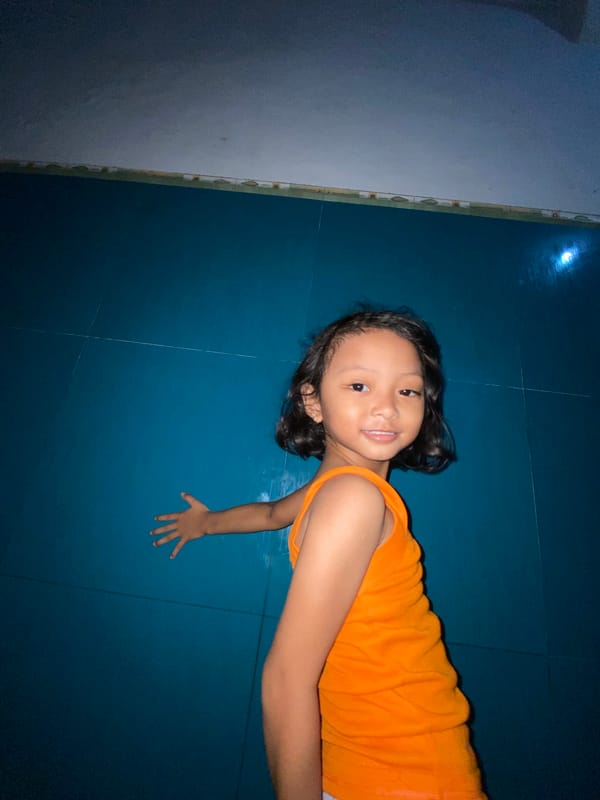 Child photographed on tiled floor in Gelam, Indonesia