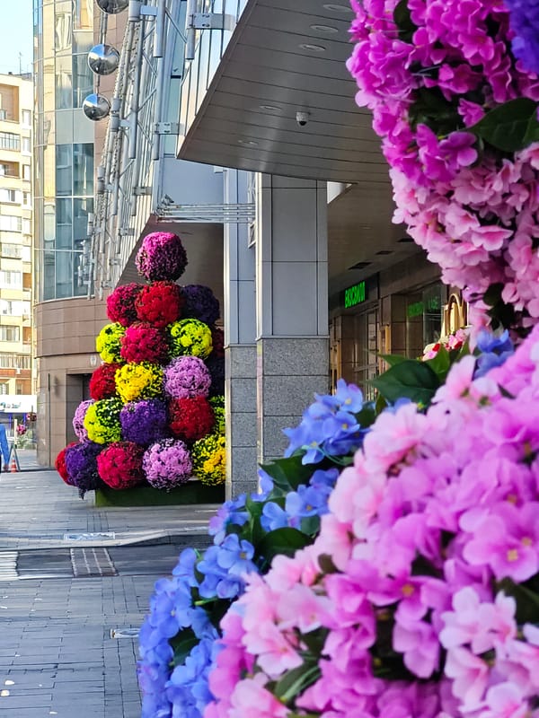 Moscow street dressed up with large floral installations and colorful storefronts