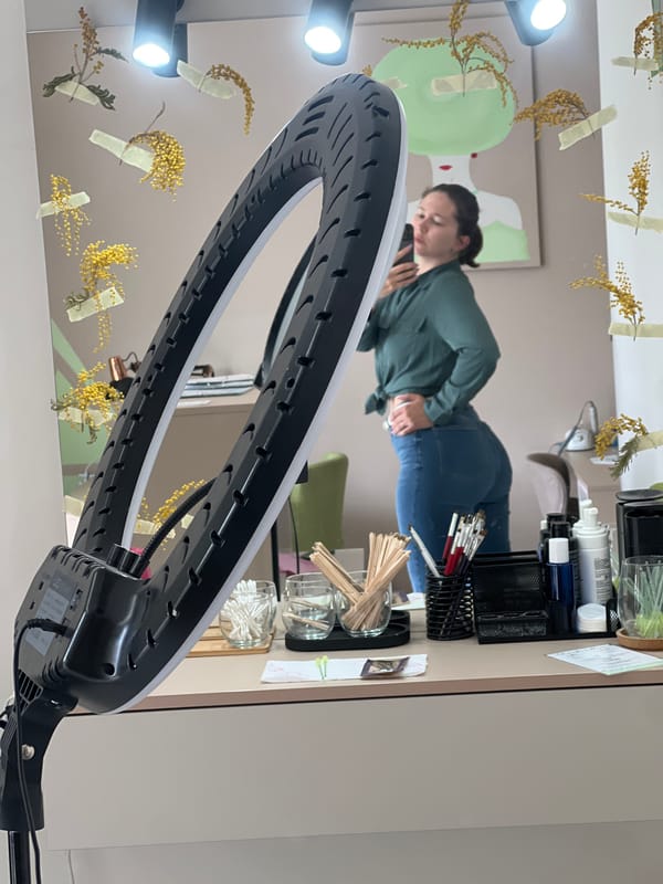 Woman uses phone near ring light setup in Podgorica room