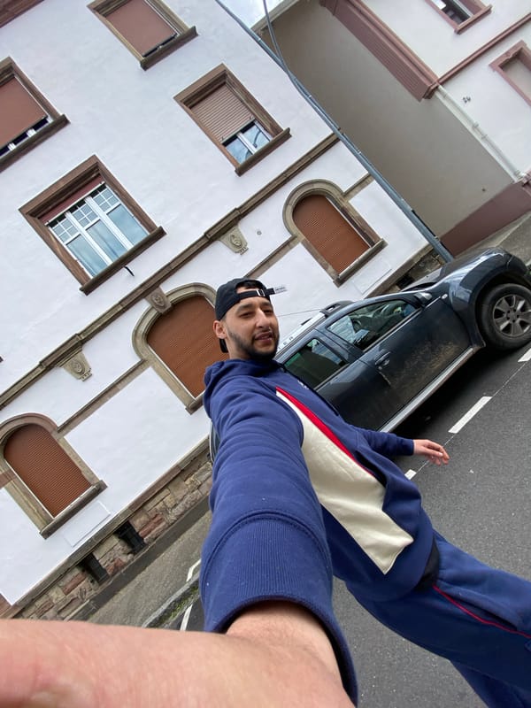 Man takes street selfies near bakery in Bischheim
